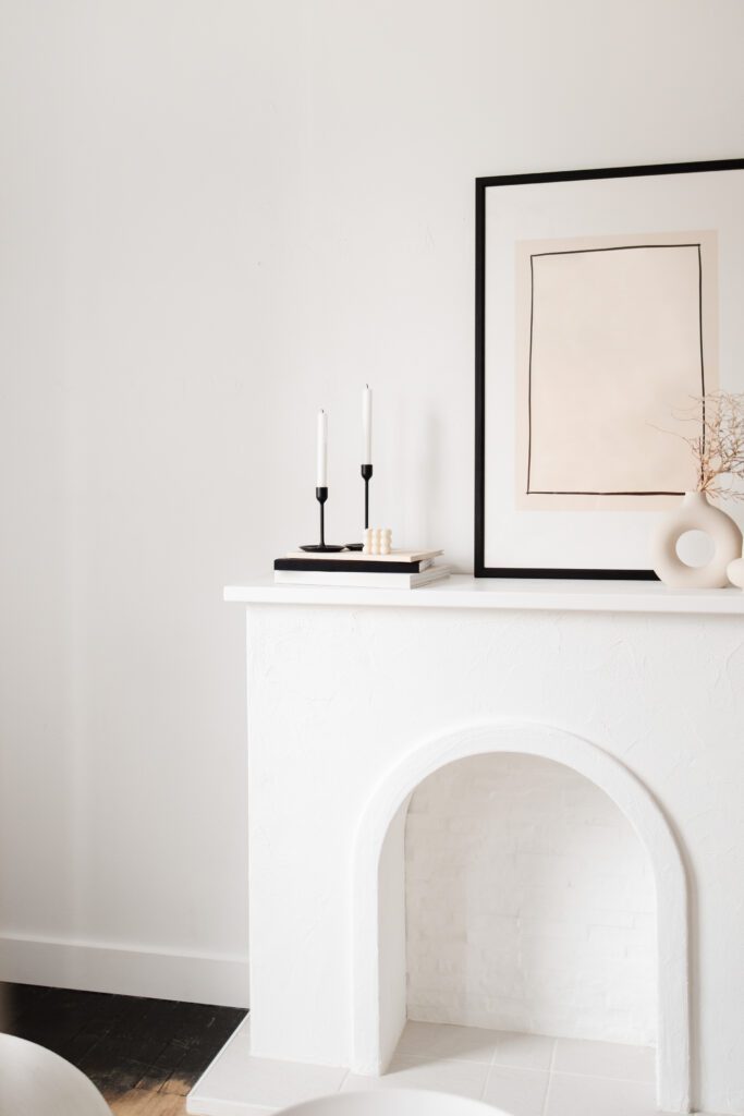 A white fireplace with minimal decorations