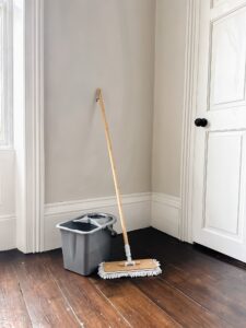 Image of a wooden mop and grey bucket