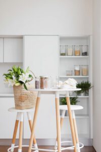 A modern white kitchen with pantry shelves
