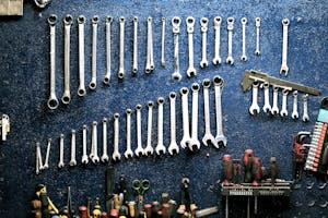 Neatly arranged wrenches and tools on a workshop wall, ideal for mechanics.