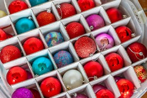 Vibrant Christmas ornaments in storage box from top view, perfect for festive decoration.