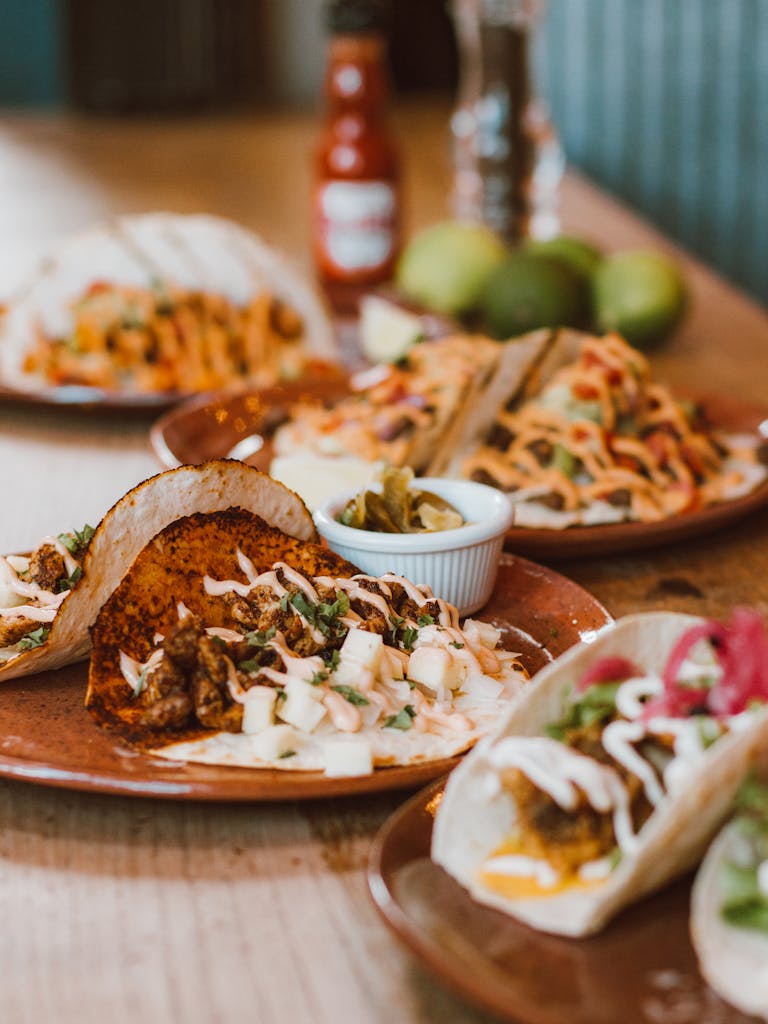 Close-up of appetizing tacos with meat, vegetables, and salsa on a rustic plate.