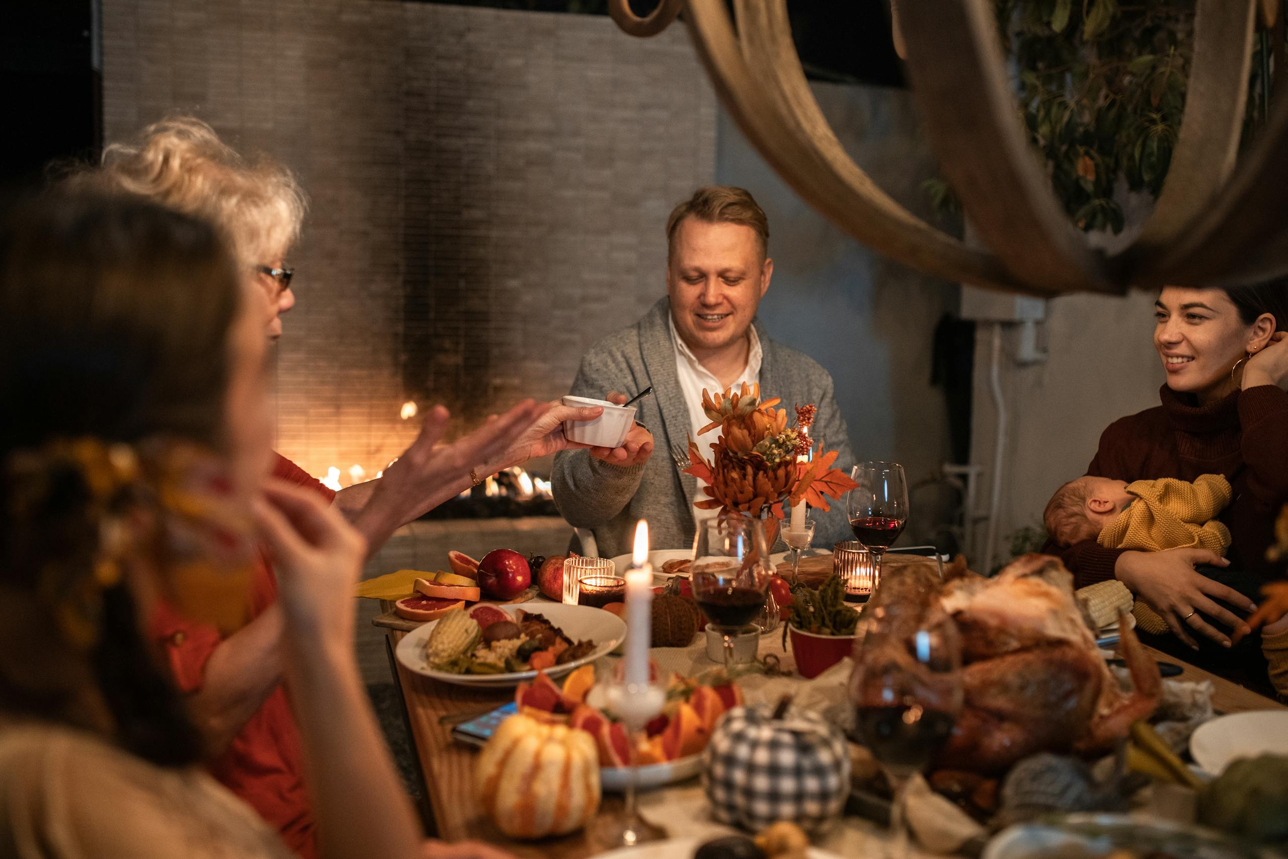 Family gathered around a festive Thanksgiving dinner table indoors.
