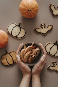 Handcrafted Halloween cookies with pumpkins on a brown surface, perfect for fall festivities.