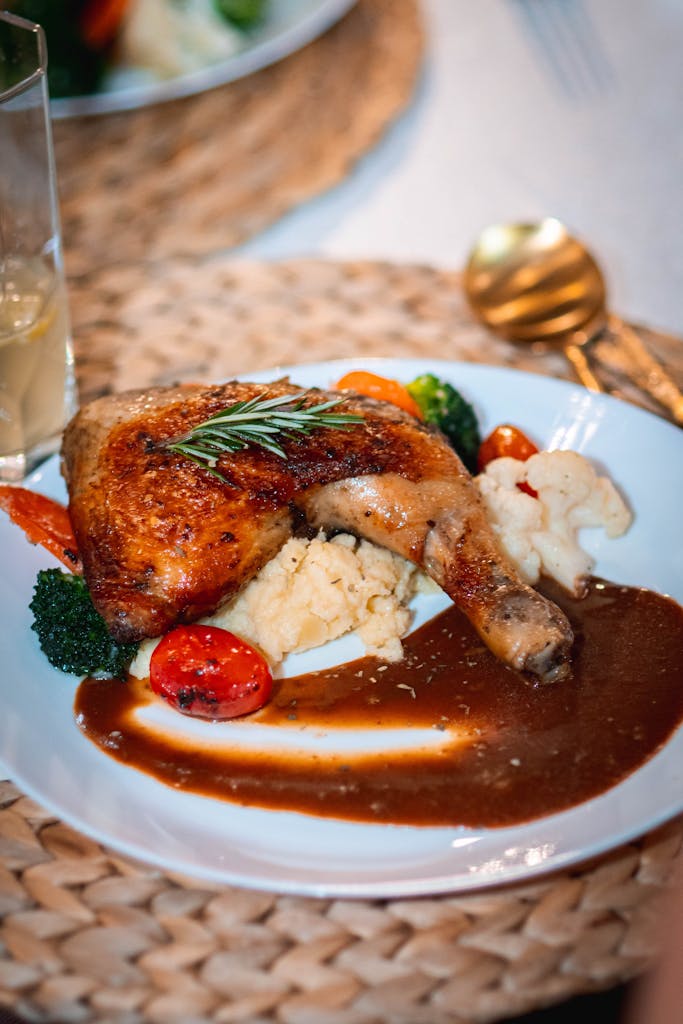 Savor a plate of perfectly roasted chicken served with vegetables and rich gravy.