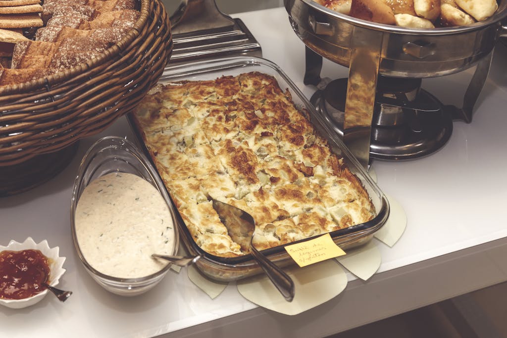 A mouth-watering baked casserole served with bread and sauce, perfect for a cozy breakfast.
