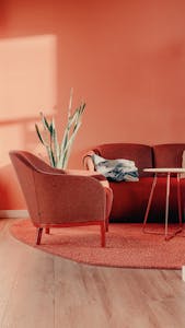 A stylish minimalist living room with peach walls and modern furniture in Berlin, Germany.