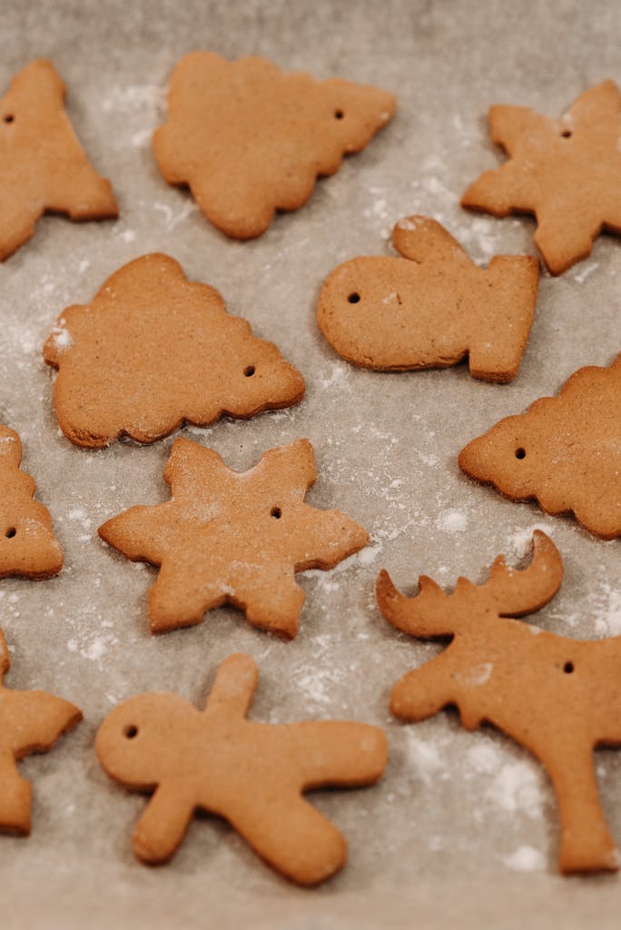 Homemade gingerbread cookies in festive shapes on a baking sheet.