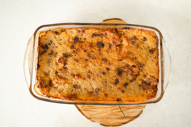 Top view of a freshly baked casserole in a glass dish on a wooden board.