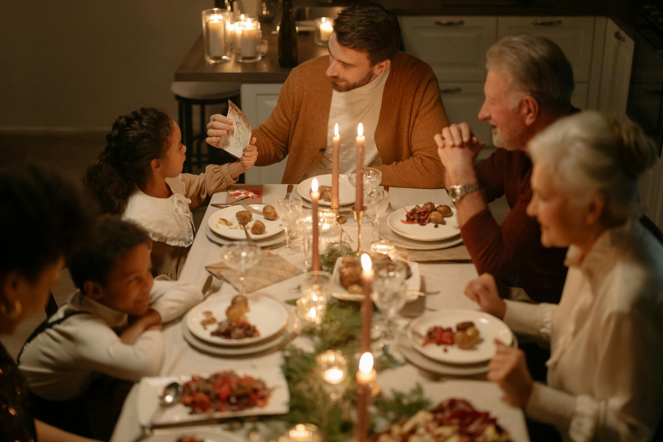 Warm and festive family dinner during Christmas with candles and joy.